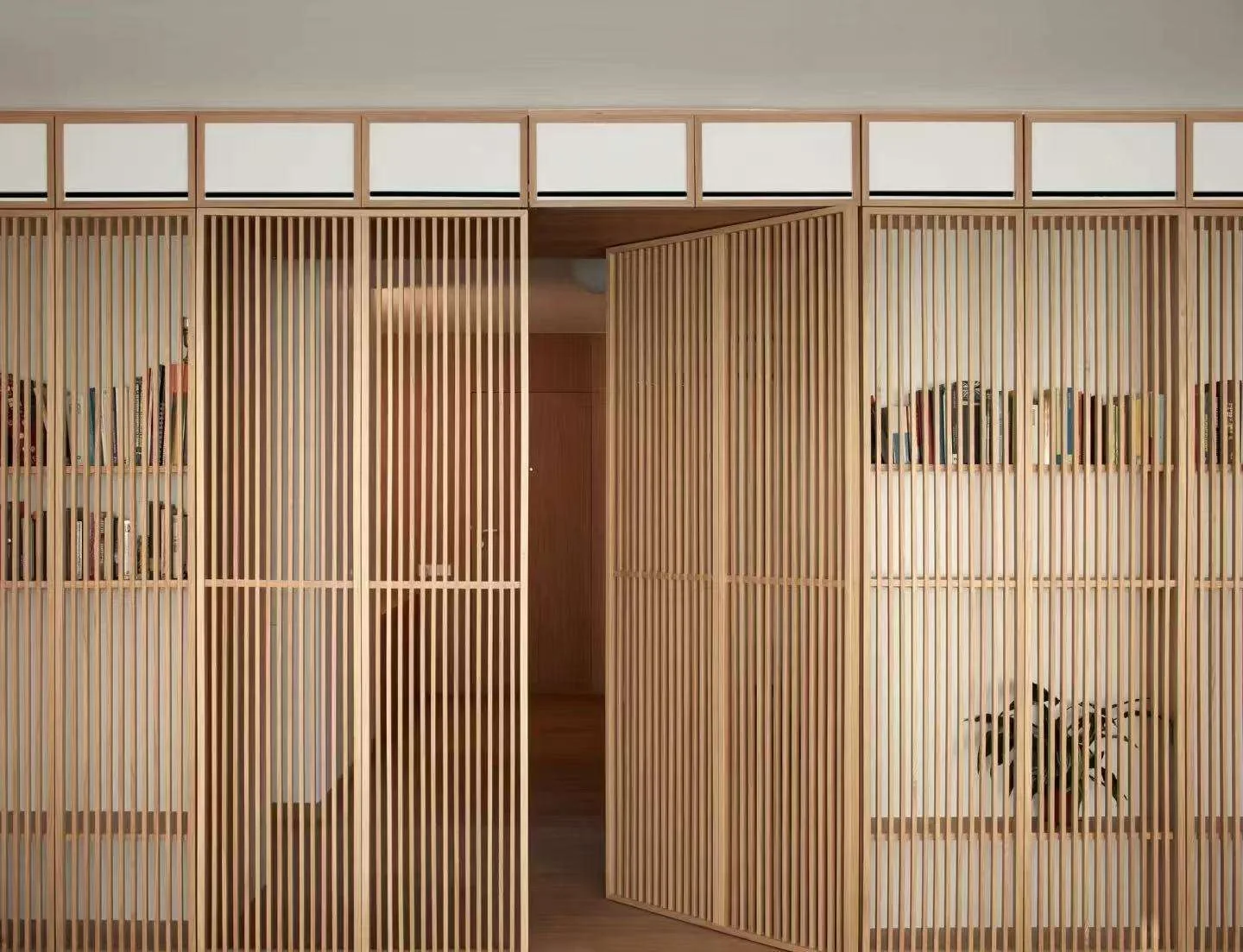 Full-height slatted wood partition with integrated shelving