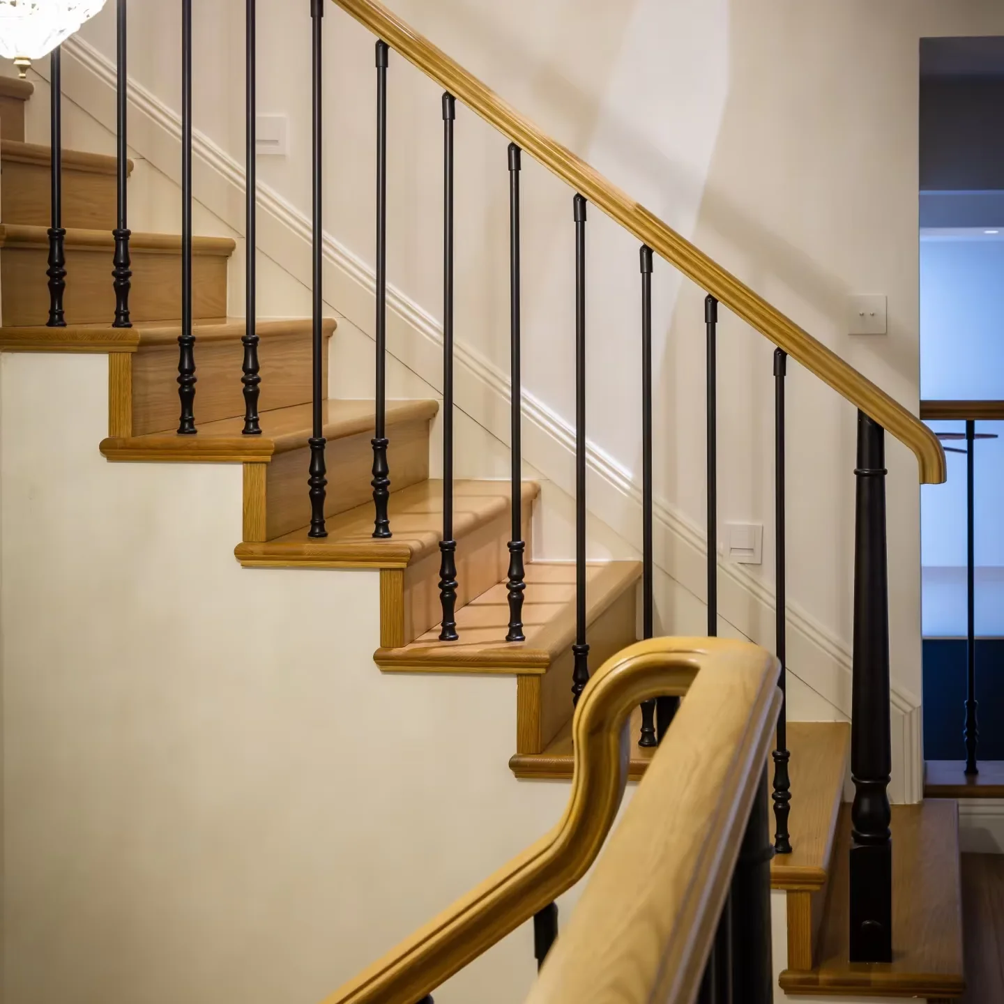 Wood stair handrail with black balusters in a residential interior
