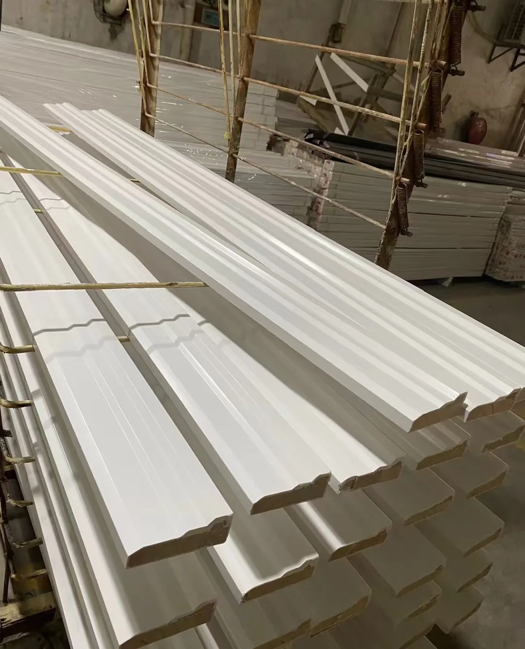 Stacked white decorative moulding lengths used as a product reference