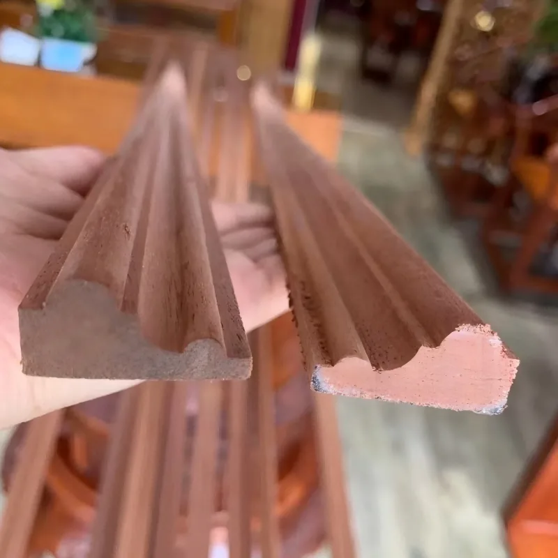 Two raw moulding profile sections held for shape comparison