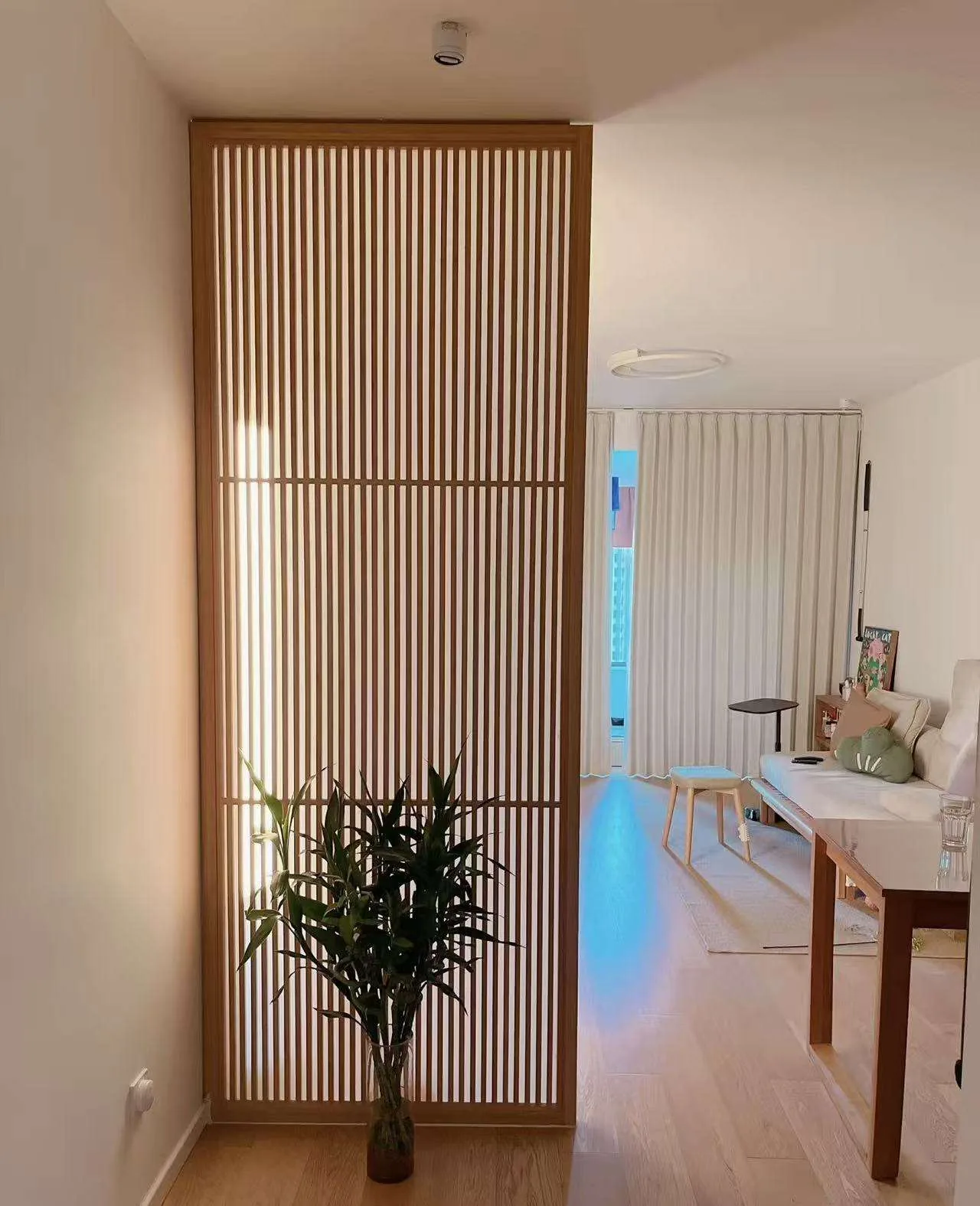 Vertical wood slat screen used as a light-filtering partition reference