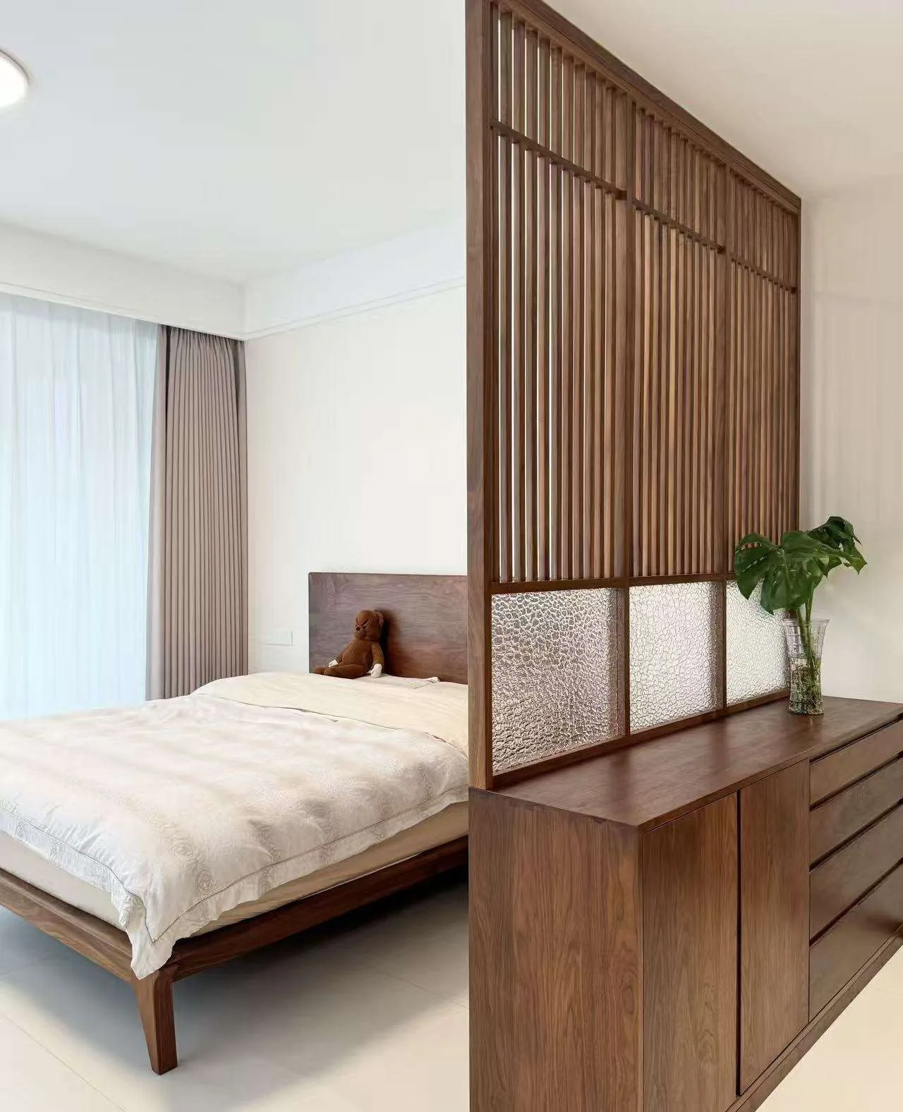 Wood screen with translucent lower panels used as a privacy design reference