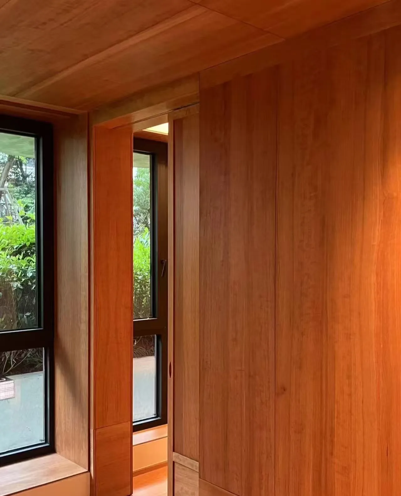 Warm wood wall panel treatment around windows used as a design reference