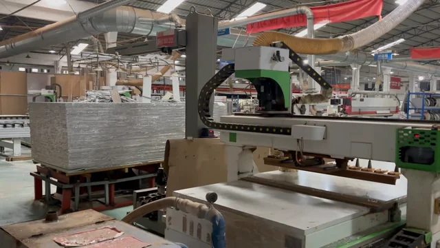 Panel beneath a gantry machine with stacked sheet material beside it