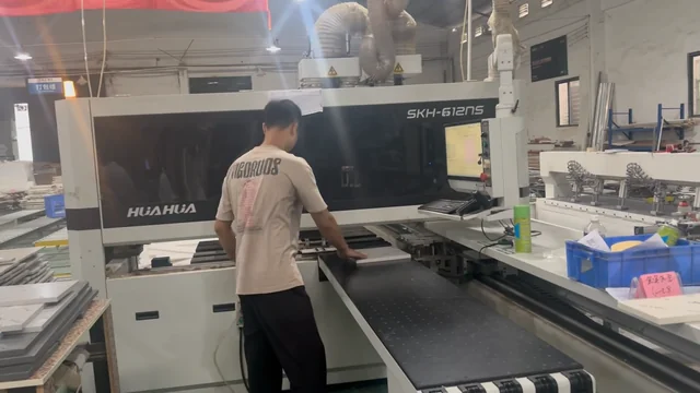 Operator handling a panel at a workshop machine
