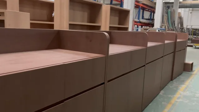 Rows of wood-tone cabinet units with open shelving behind them
