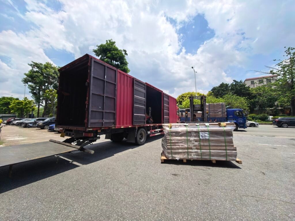 Wrapped pallet in front of a side-opening box truck with forklift at loading site