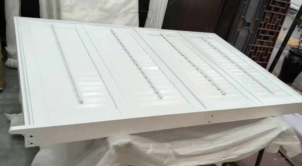 White solid wood plantation shutter panels with closed louvers and visible front tilt rods